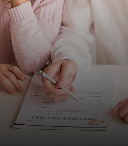 Close-up of a couple reviewing and signing a divorce decree together, reflecting a collaborative divorce process.