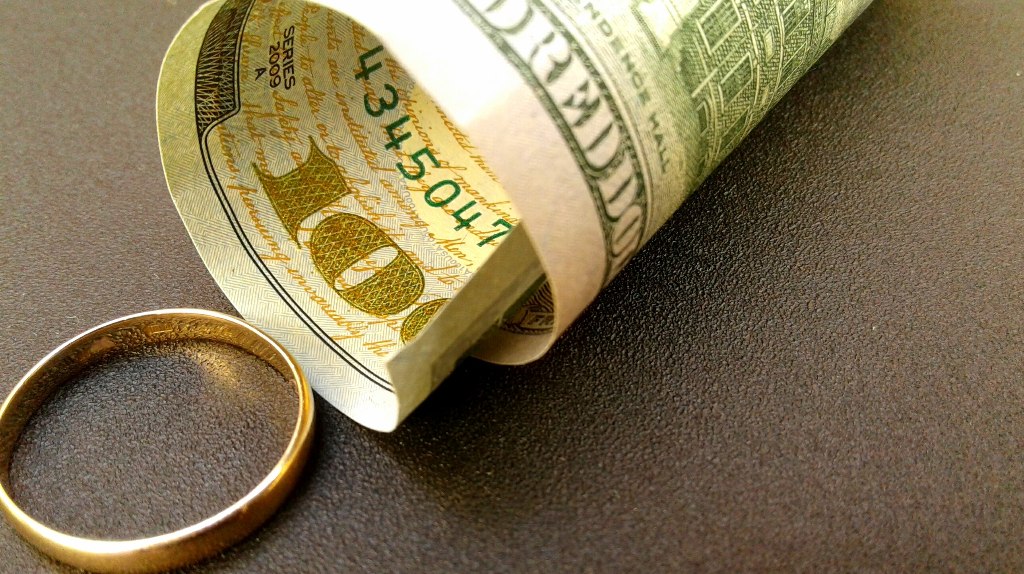 100 dollar bill and wedding ring