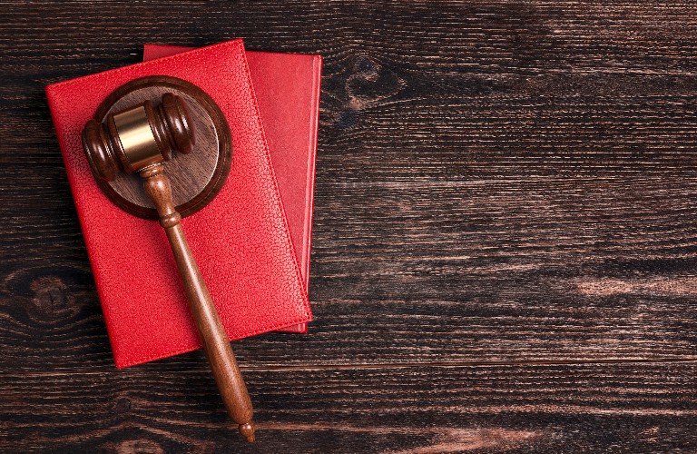 Wooden judges gavel lying on legal books