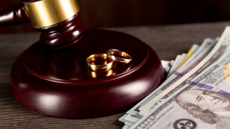 Judge's gavel, wedding rings and money