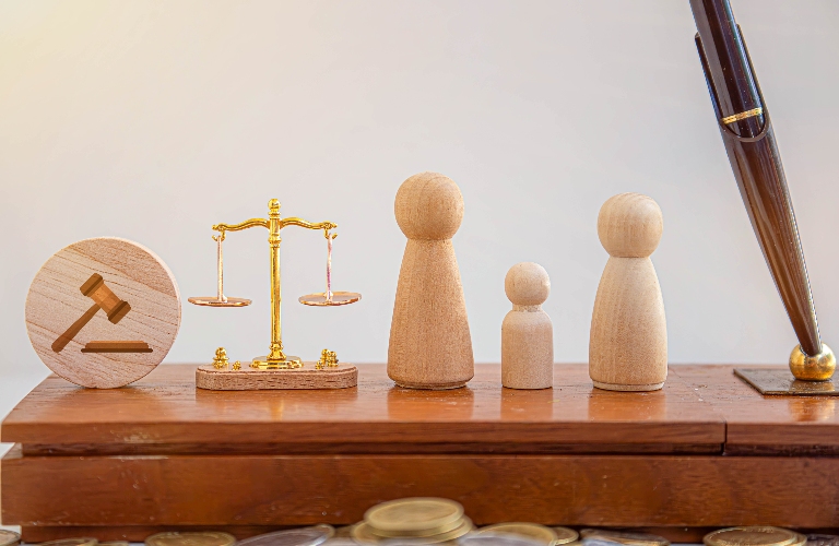 Wooden family figures, judge's gavel and scales of justice