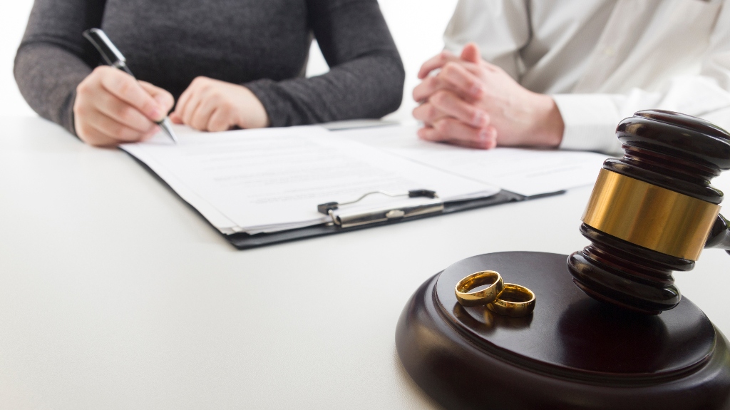 Hands of wife, husband signing decree of divorce