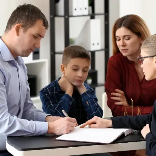 Parents meeting with a family law attorney to review divorce documents